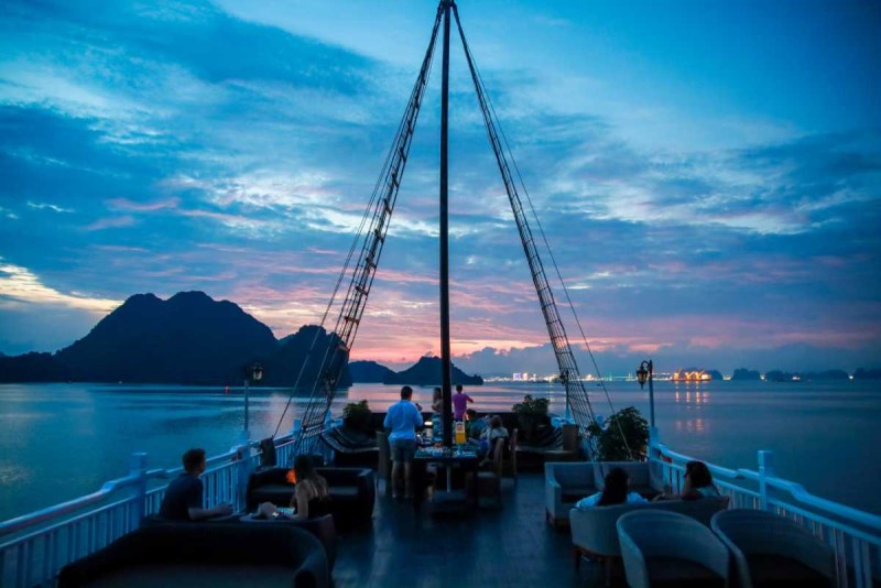 Guests relaxing on a cruise deck with panoramic views of limestone formations