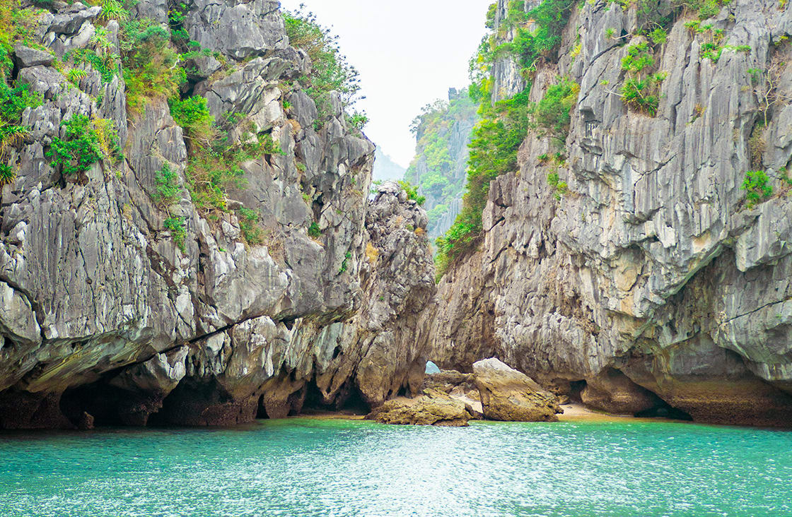 Limestone karsts rising from the tranquil bay waters