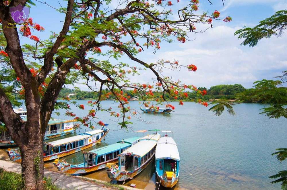 A dragon boat glides along the Perfume River amid Hue’s misty ambiance.