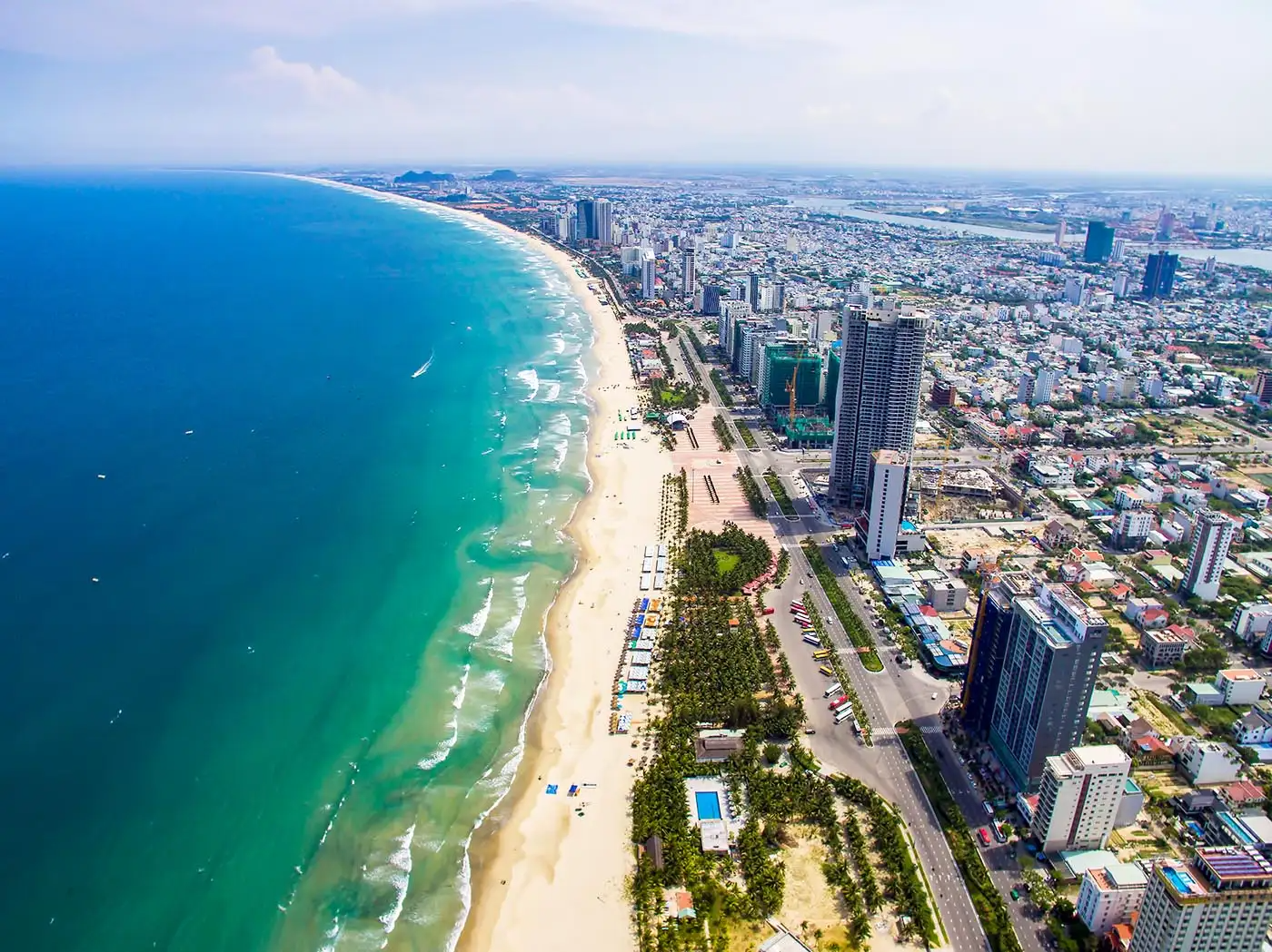 Da Nang's stunning coastline with My Khe Beach and the modern city skyline in the background. The Marble Mountains and the iconic Golden Bridge are must-see highlights for every visitor to Central Vietnam.